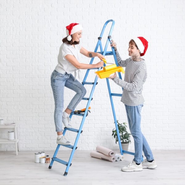Young,Couple,With,Santa,Hats,And,Paint,Roller,During,Repair